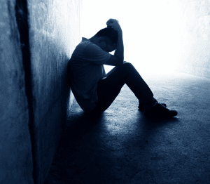 person with ptsd sitting with their head in their hands