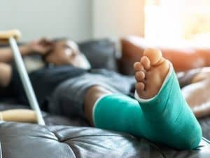 person laying in bed with cast on leg after personal injury